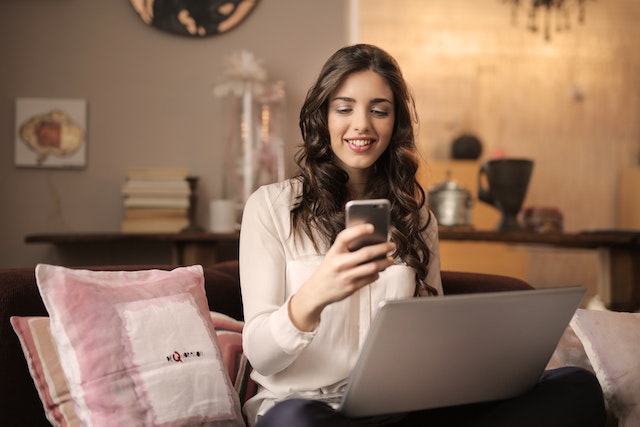 person-working-on-laptop-looking-at-phone