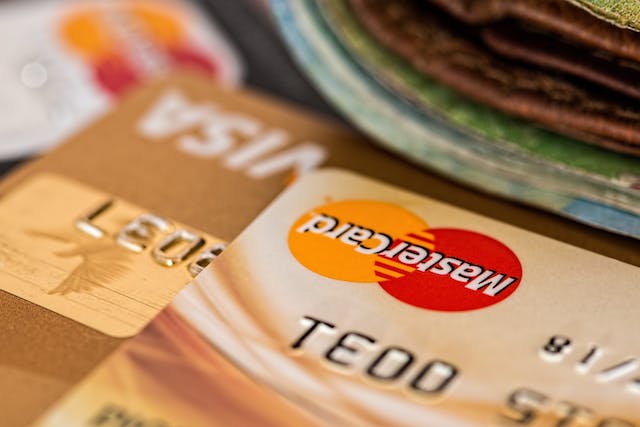 stack-of-credit-cards-on-table-with-money-in-background