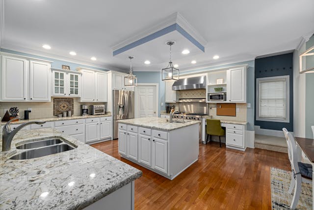 kitchen-with-white-cabinets-granite-counters-and-hard-wood-flooring