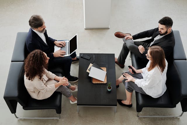 a-group-of-four-professionals-sitting-in-a-modern-office-lounge-engaged-in-a-discussion