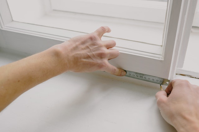 contractor-using-a-ruler-to-note-down-measurements-on-a-window