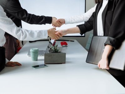 businesspeople-shaking-hands-across-a-conference-table-during-a-meeting