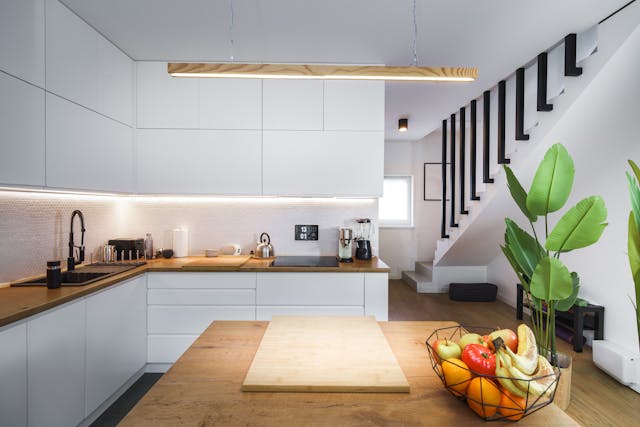 modern-white-kitchen-with-wood-countertops-and-fruit-bowl