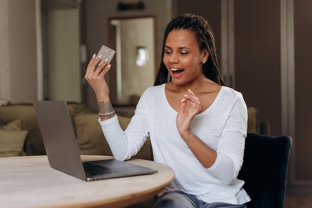 a tenant in a white shirt holding a credit card making an online payment