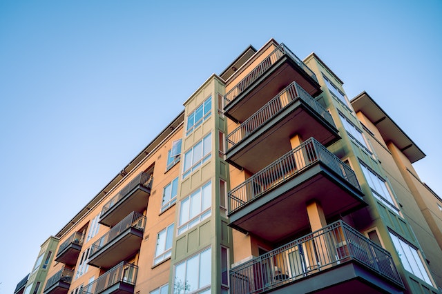 apartment building photographed from a low angle with a clear blue sky in the background