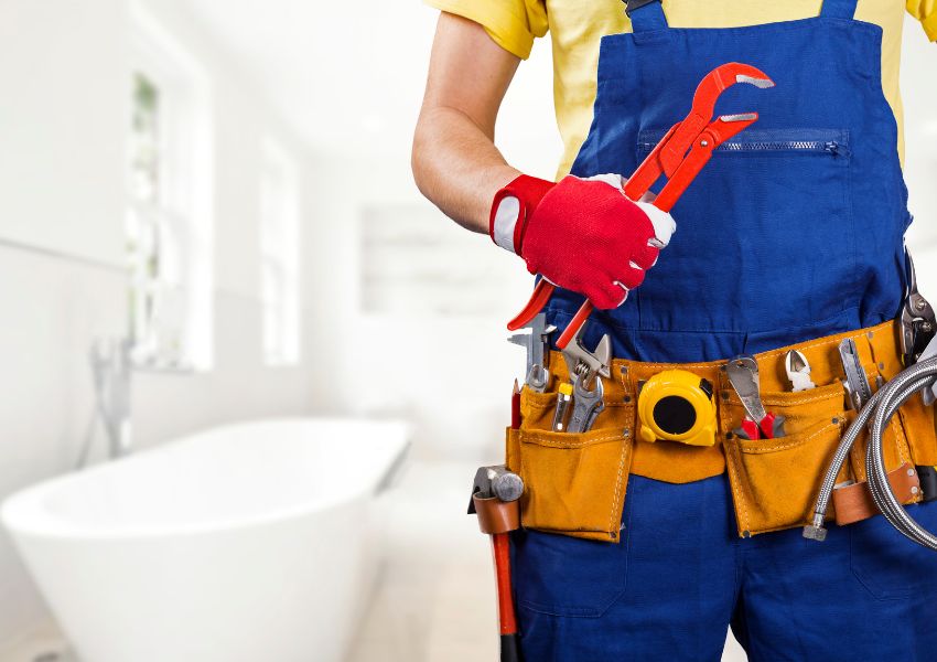 contractor wearing a utility belt and holding a wrench