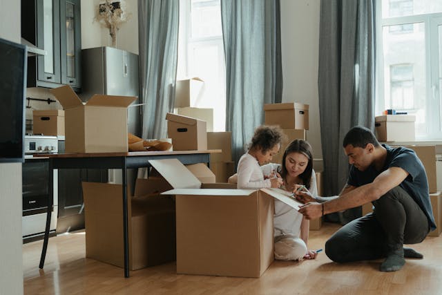 family-of-three-unpacking-and-playing-in-boxes-while-moving-in