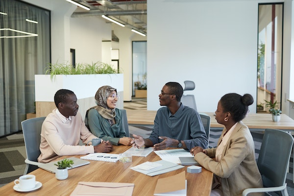 four people sitting around a conference table having a meeting