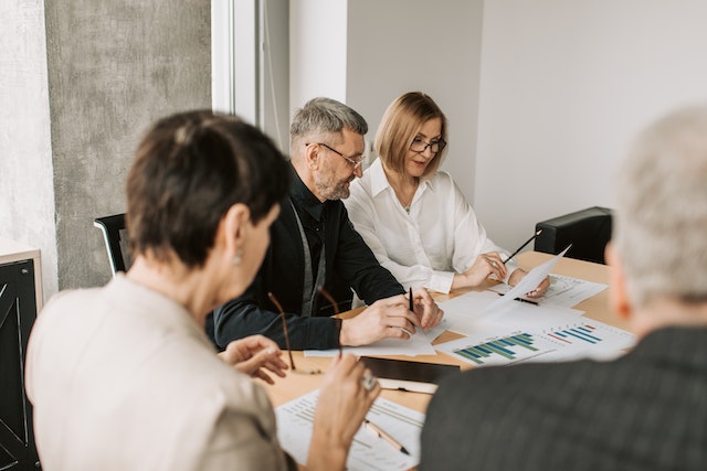 group of property managers in a conference room looking over various documents