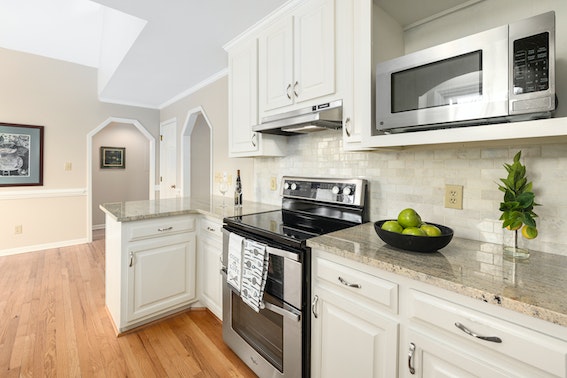 kitchen with white cabinets, wood flooring, and stainless steal appliances