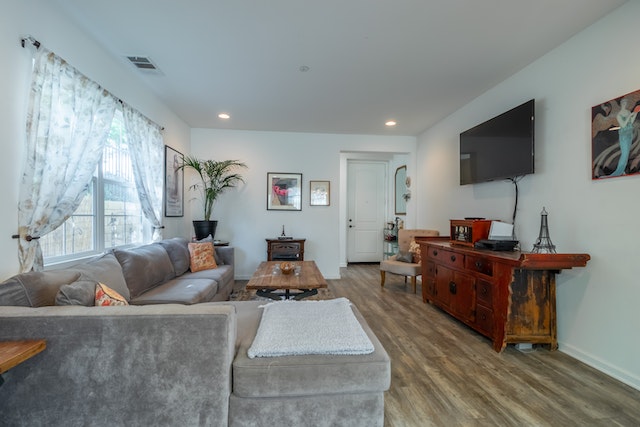 living room with a grey couch and wall-mounted tv