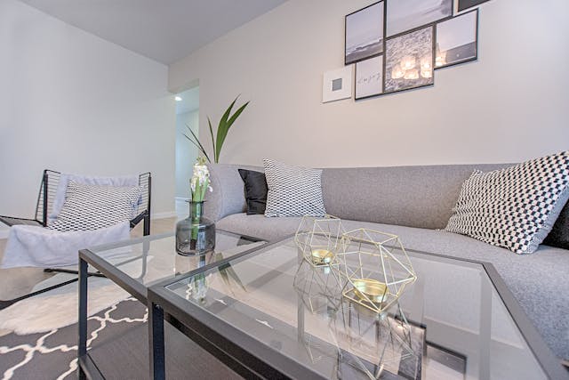 neutral-colored-living-room-filled-with-grey-furniture-and-a-glass-table