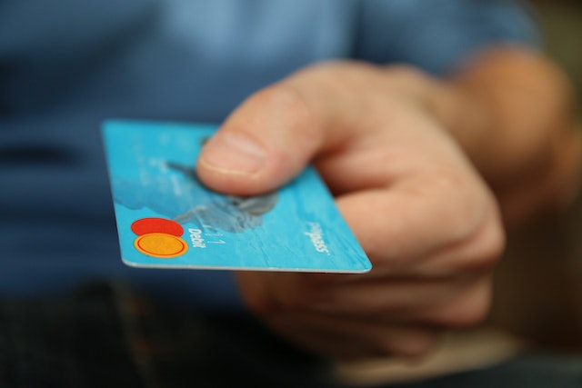 person holding a blue credit card