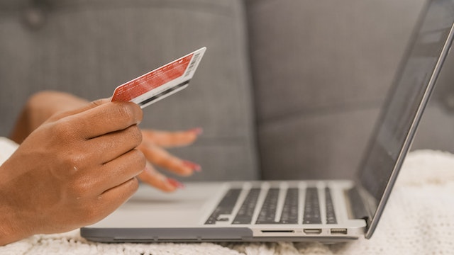person holding a credit card as they make an online payment