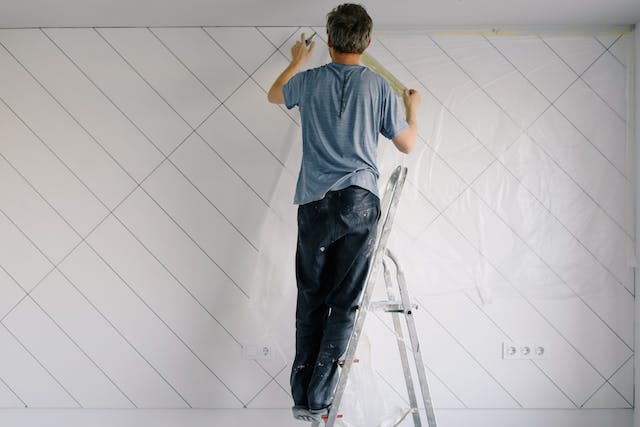 person-on-step-ladder-installing-new-tile