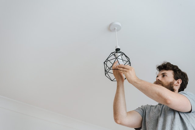 person standing on a ladder to change a light bulb