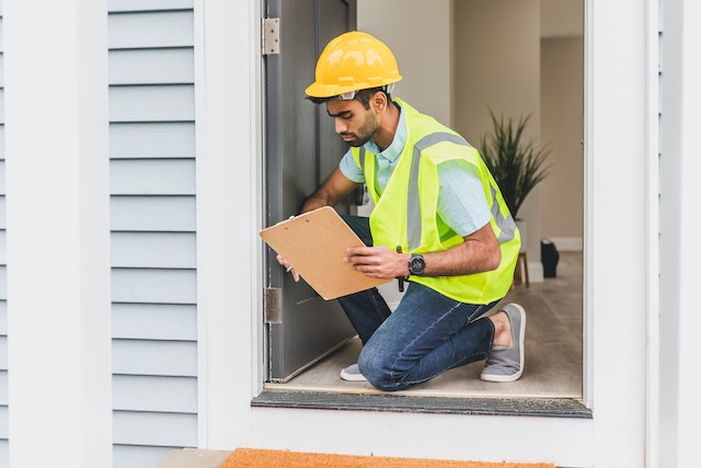 person in hardhat kneeling in front of a door