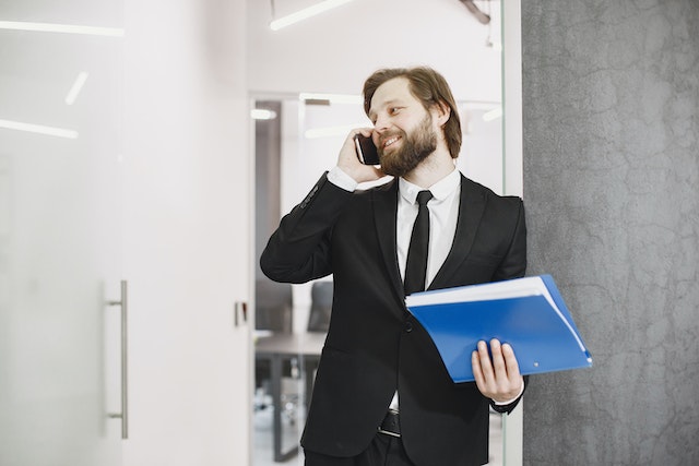 property manager holding a blue folder while talking on the phone