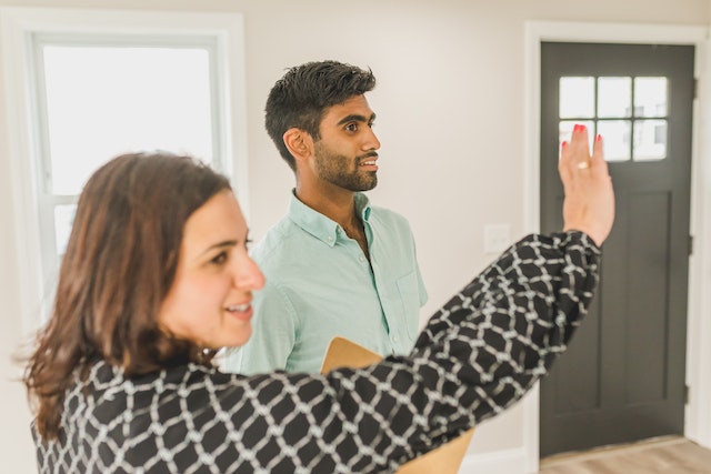 real estate agent giving a prospective tenant a tour of an unfurnished house