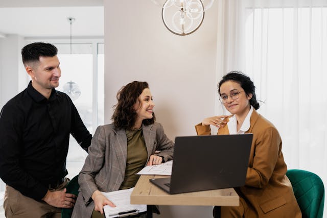 three-professionals-having-a-discussion-around-a-laptop