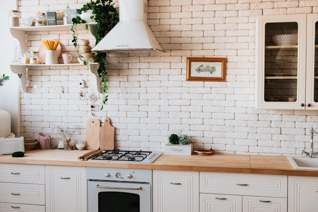 white-brick-kitchen-with-white-cupboards-and-a-wooden-countertops