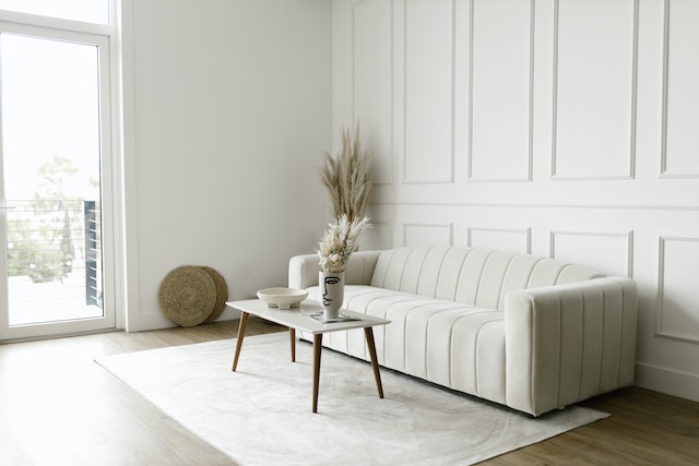 white living room with a white couch, and a balcony