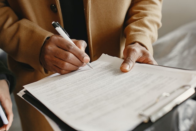 Person holding a document and signing it