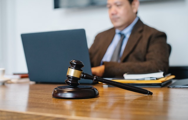 judge sitting at their desk with a gavel in the foreground