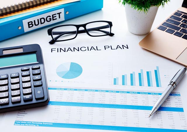 Financial plan with calculator and folded glasses on a desk