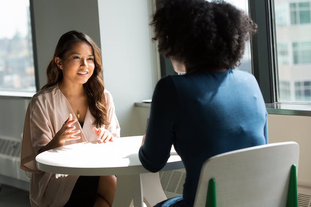 two-people-sitting-at-a-table-having-a-conversation