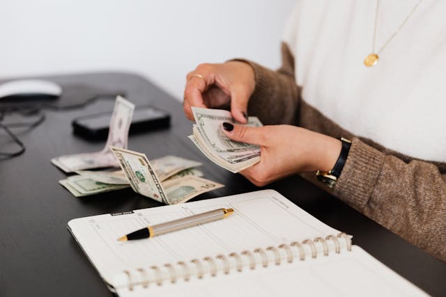 someone counting money at a desk
