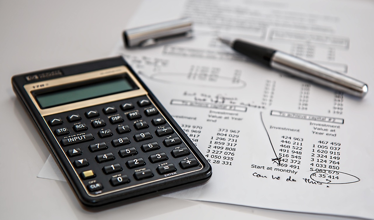 A calculator and financial document on a table.