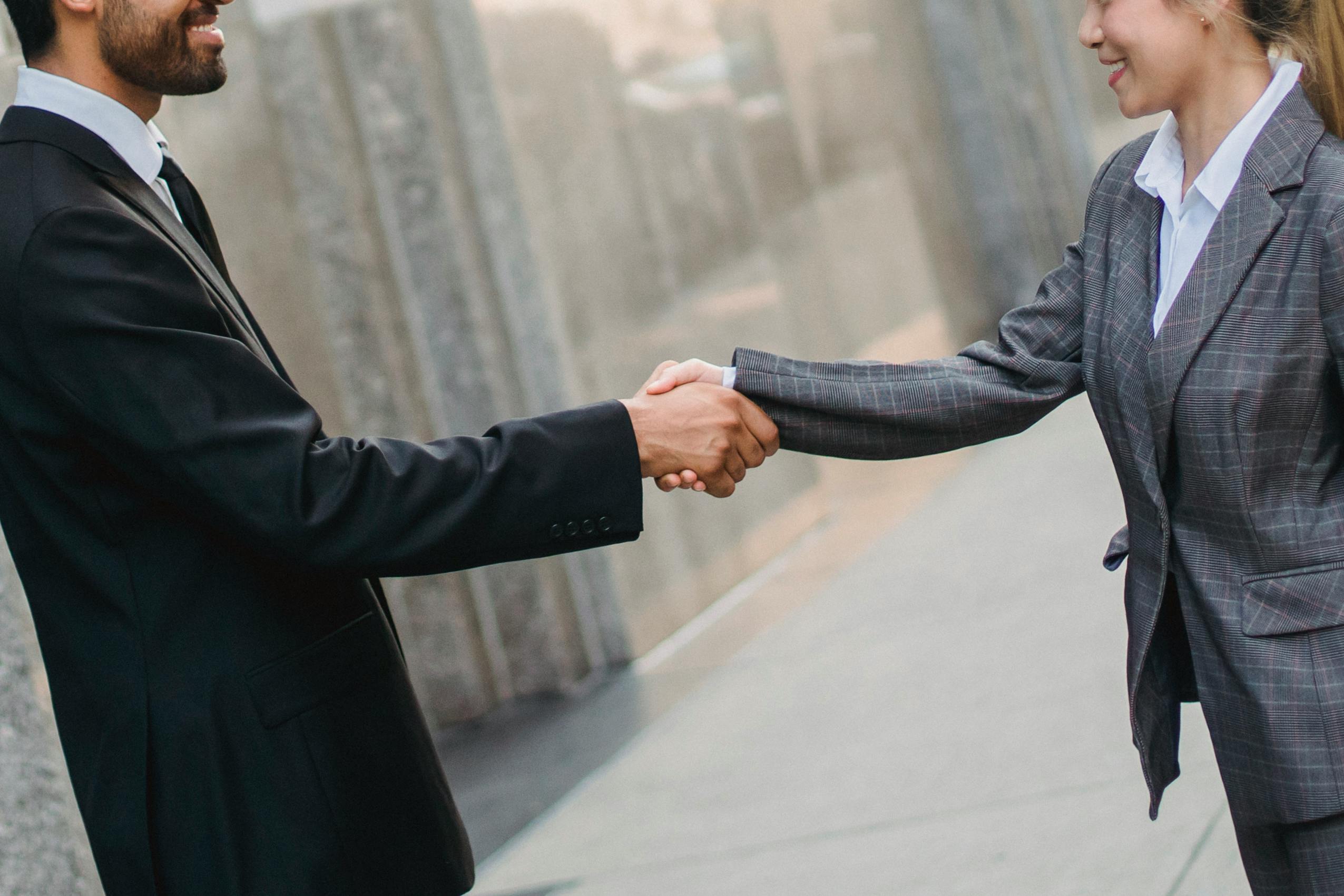 A man and woman in business suits shaking hands.