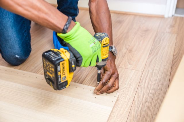 person drilling wood with a power tool