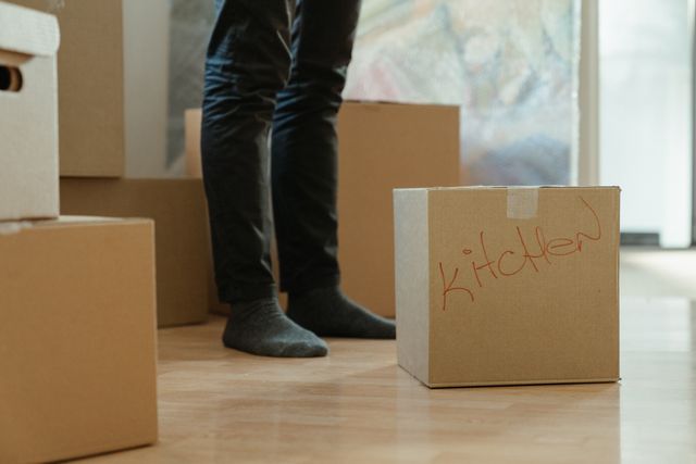 person standing next to cardboard boxes