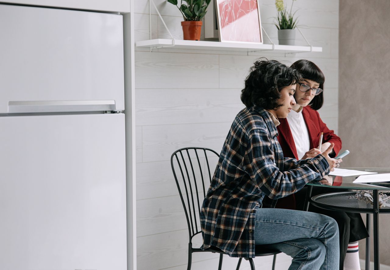 Landlord and Tenant Discuss Payment Options at a Kitchen Table