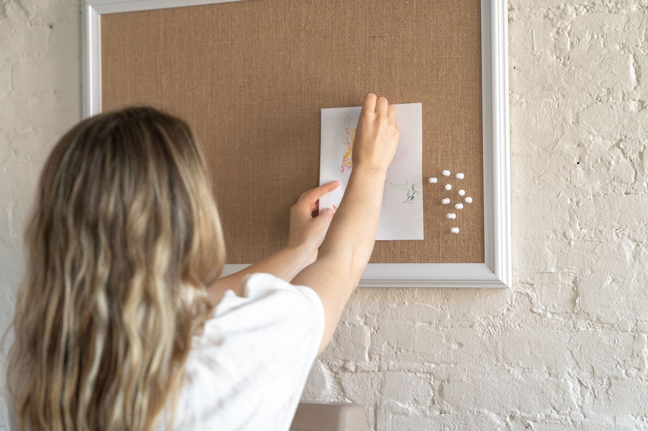 Person posting an advert on a bulletin board